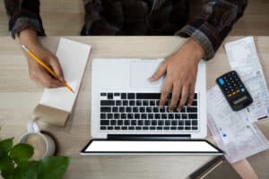 Cálculo del presupuesto de una tienda online con ordenador y calculadora sobre un escritorio